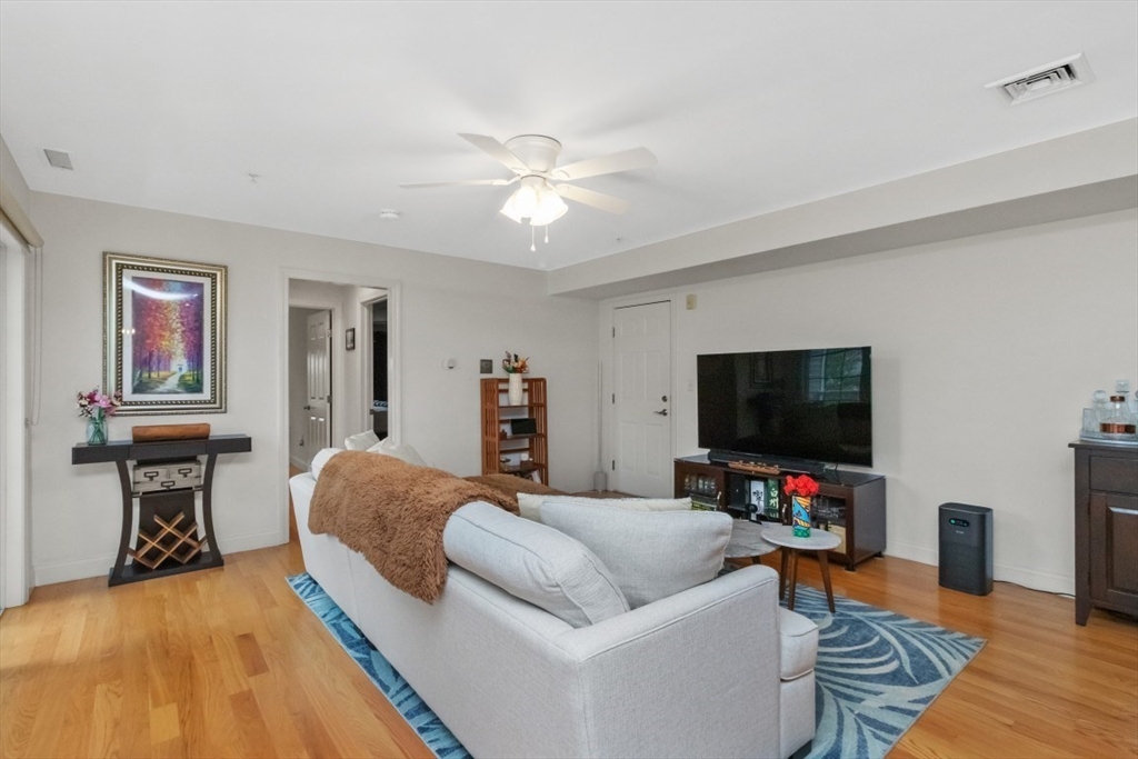 29 Spruce Street, Unit 23 Waltham, MA 02453 - Photo 10 of 26 a living room with furniture and a flat screen tv