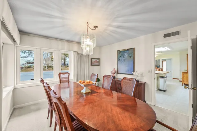 a view of a dining room with furniture a chandelier and wooden floor
