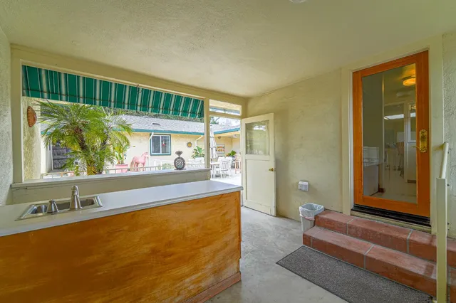 a view of a patio with table and chairs with wooden fence and plants