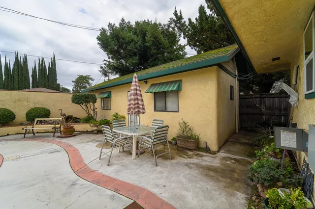a living room with furniture a window and a potted plant