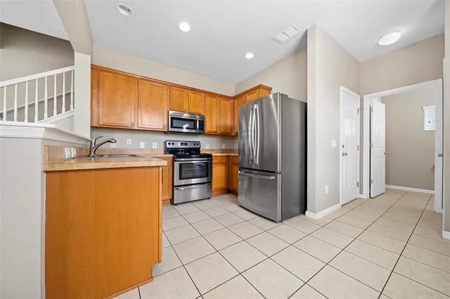 a kitchen with stainless steel appliances granite countertop a refrigerator sink and microwave