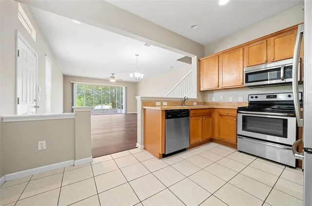 a kitchen with granite countertop a stove top oven microwave and cabinets