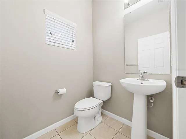a bathroom with a sink toilet and a mirror
