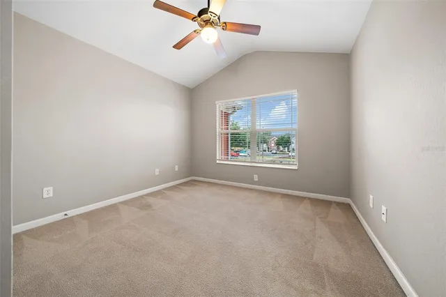 an empty room with windows and ceiling fan