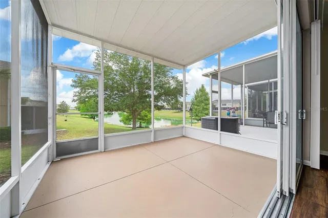 a view of an empty room with wooden floor and door