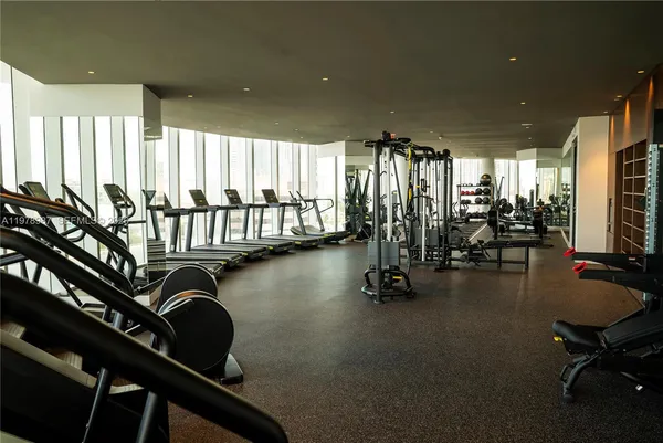 a room with gym equipment and large windows