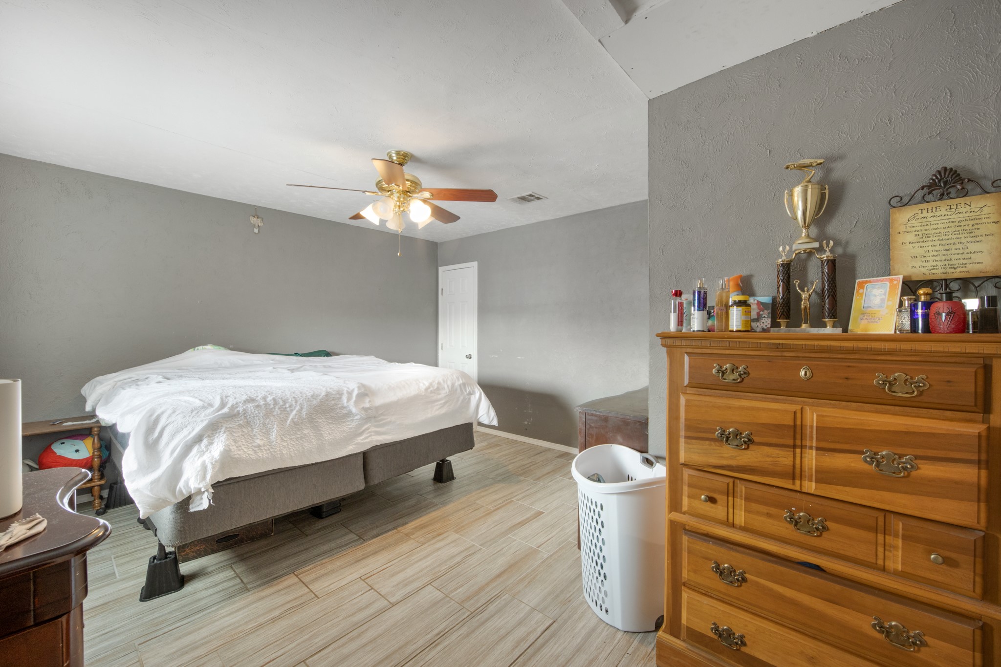 8901 Woodlyn Road Houston, TX 77078 - Photo 15 of 22 a bedroom with a bed and a dresser with wooden floor