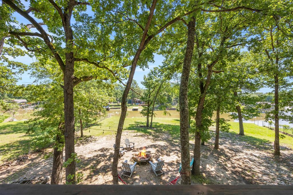 7110 Apache Circle Mabank, TX 75156 - Photo 29 of 39 Shaded outdoor area featuring mature trees, string lighting, and a fire pit