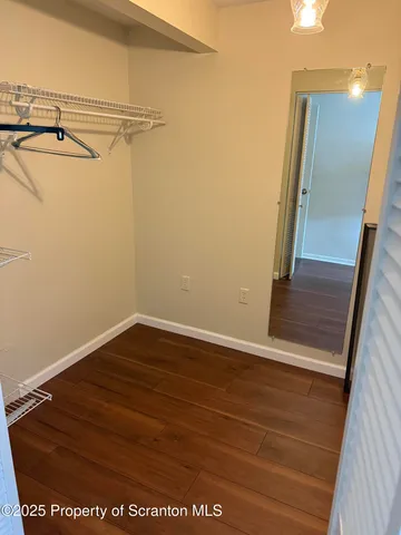 a view of a room with wooden floor and windows