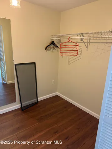 an empty room with wooden floor and mirror