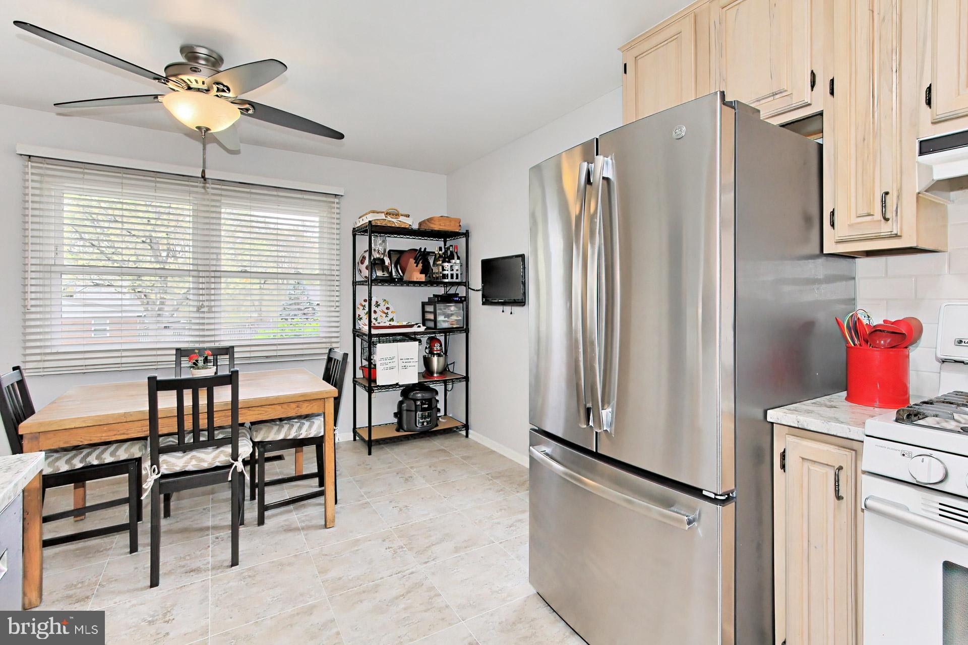 6011 Meriwether Lane Springfield, VA 22150 - Photo 14 of 53 a kitchen with stainless steel appliances a refrigerator and a dining table