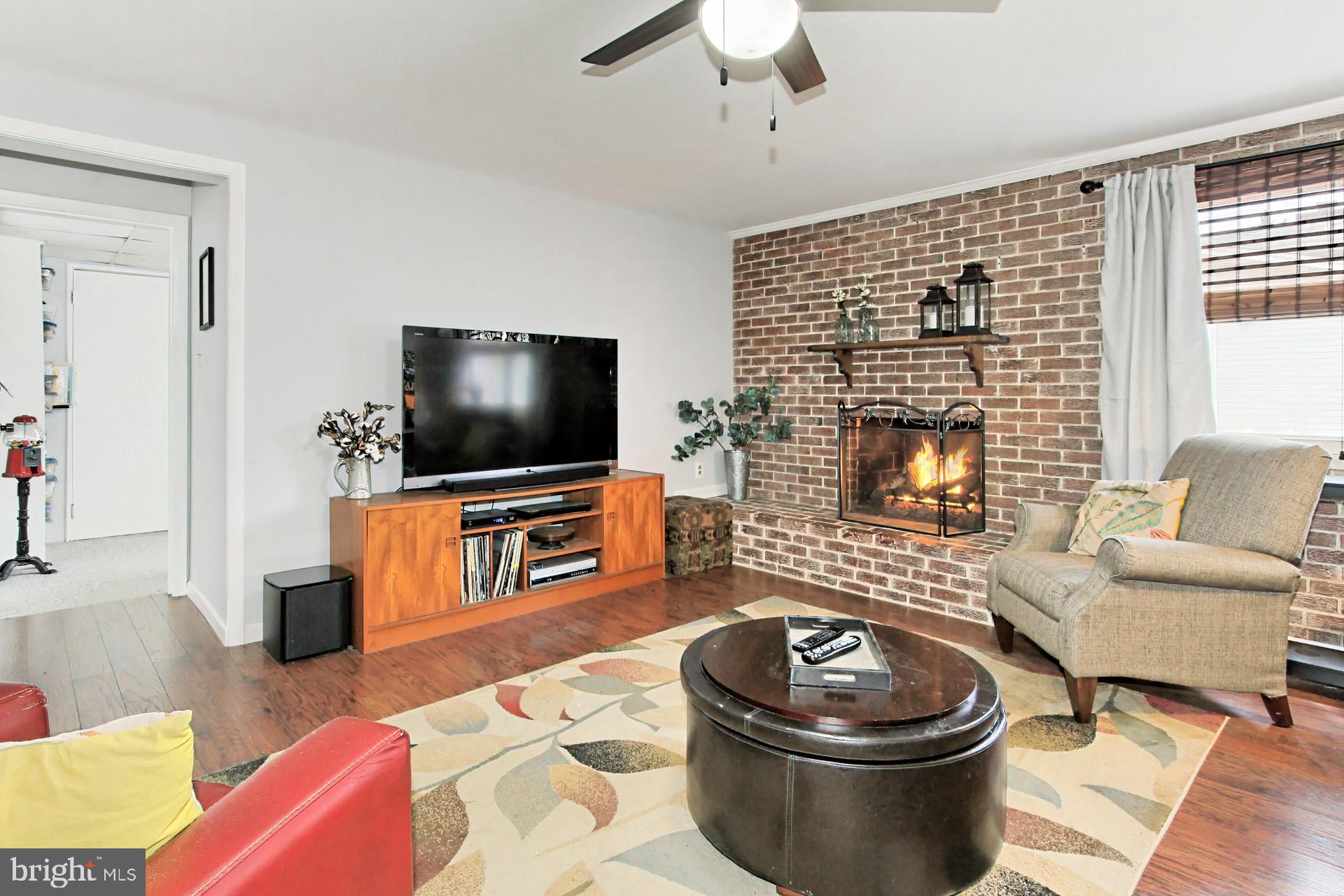 6011 Meriwether Lane Springfield, VA 22150 - Photo 31 of 53 a living room with furniture a flat screen tv and a fireplace