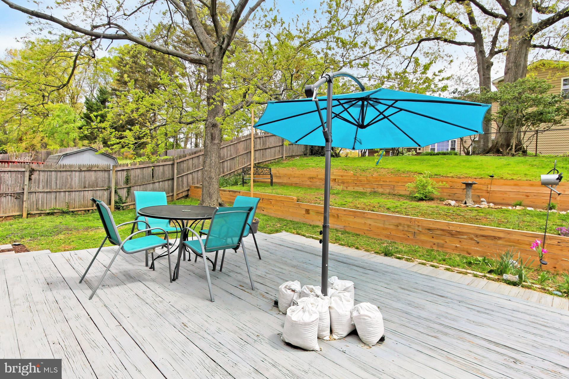 6011 Meriwether Lane Springfield, VA 22150 - Photo 38 of 53 a view of a deck with a table and chairs under an umbrella