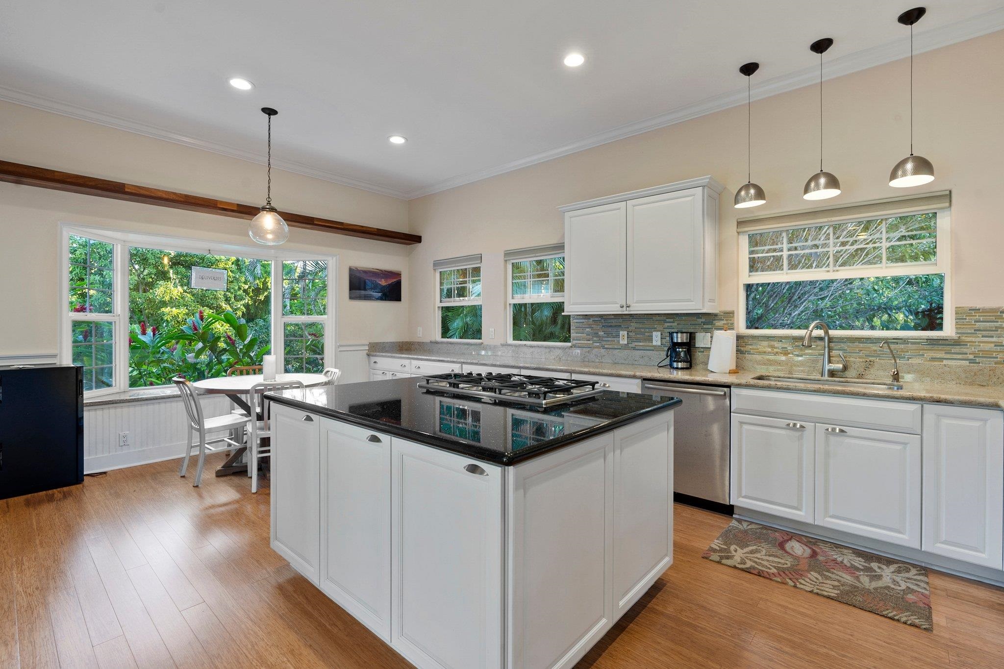 370 Waiama Way Haiku, HI 96708 - Photo 3 of 24 a kitchen with a stove a sink a center island and wooden floor