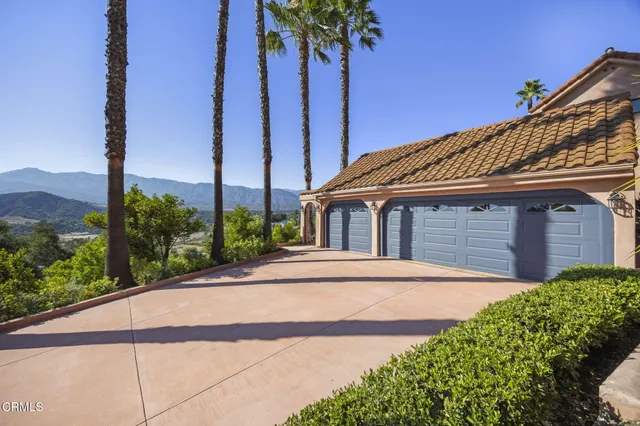 a front view of a house with a yard and potted plants