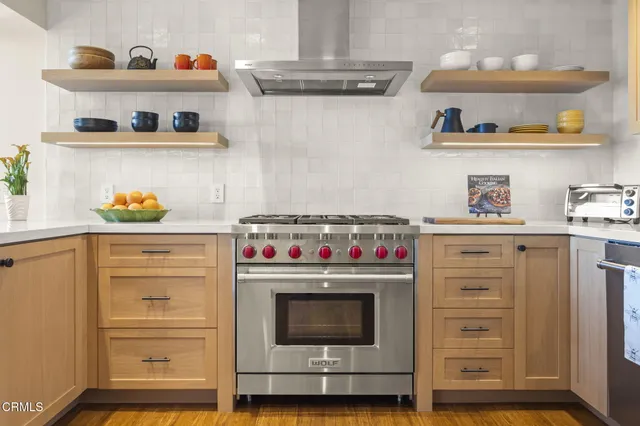 a kitchen with a stove and wooden floor