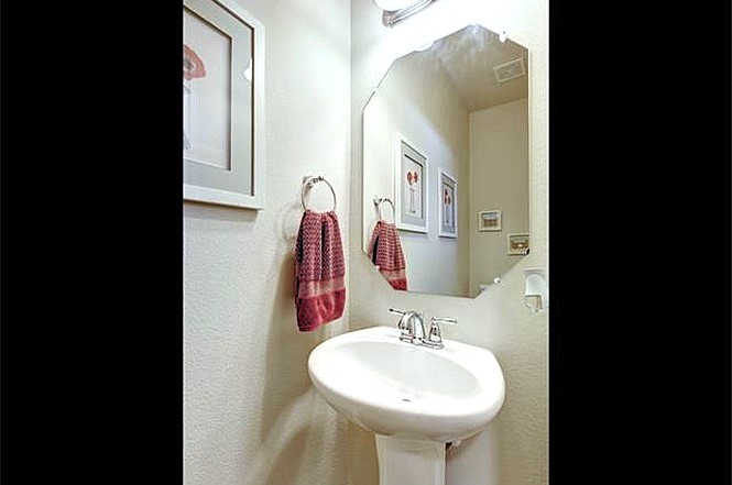 14001 Avery Ranch Boulevard, Unit 801 Austin, TX 78717 - Photo 10 of 26 A compact and functional bathroom features a classic pedestal sink beneath an angular wall mirror.