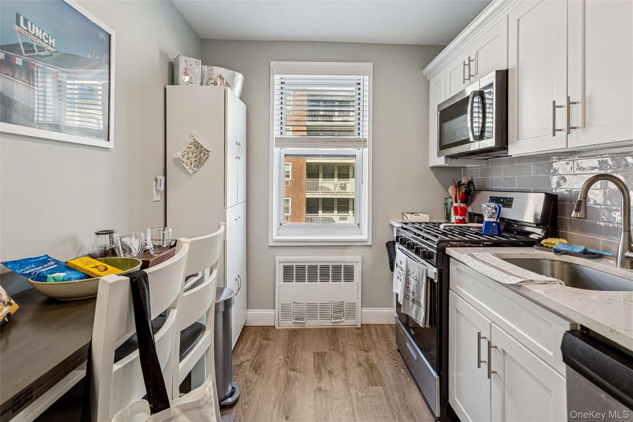 700 Shore Road, Unit 5U Long Beach, NY 11561 - Photo 14 of 21 a kitchen with stainless steel appliances a stove a sink and a refrigerator