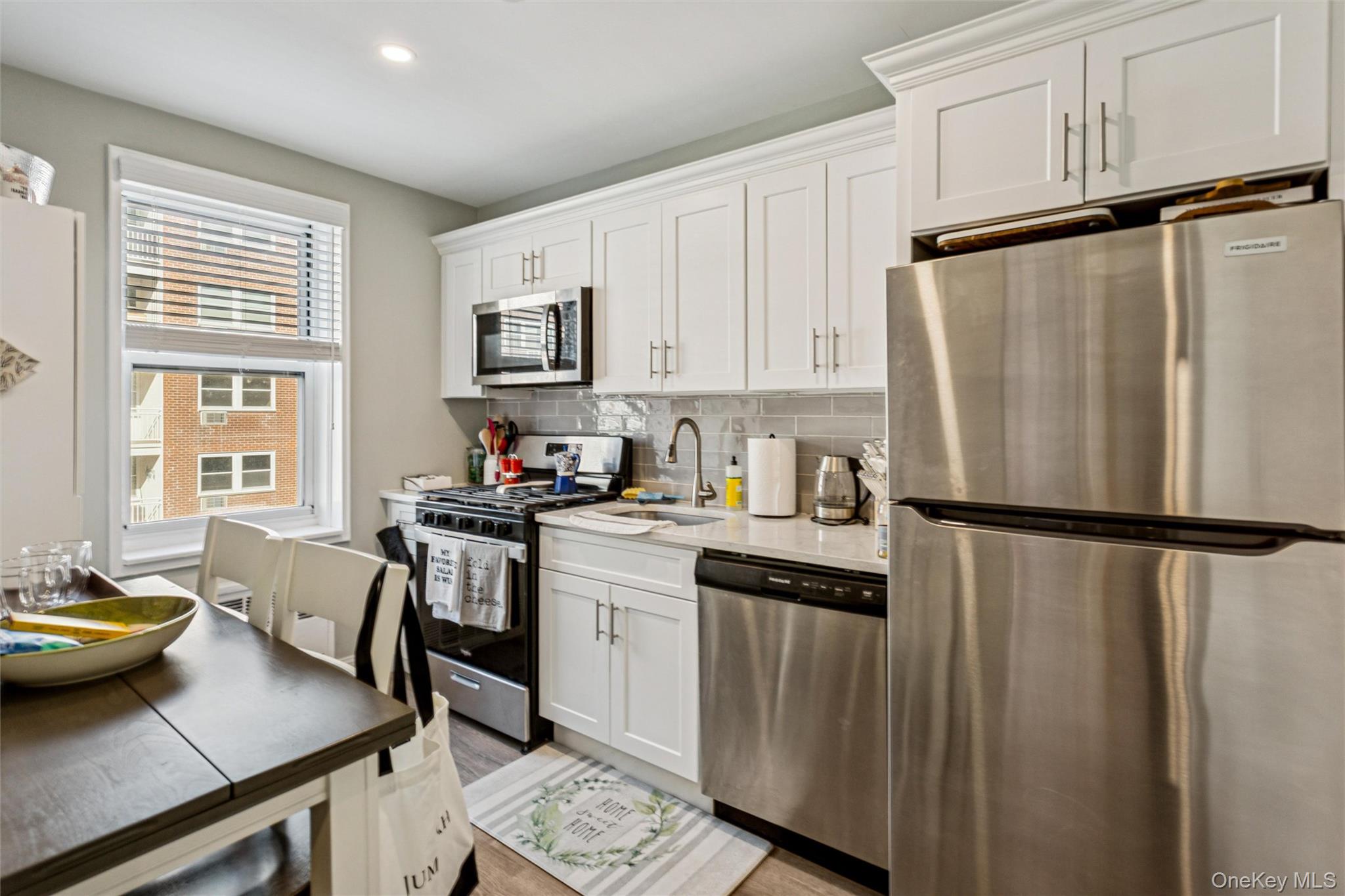 700 Shore Road, Unit 5U Long Beach, NY 11561 - Photo 16 of 21 a kitchen with stainless steel appliances granite countertop a refrigerator sink and stove