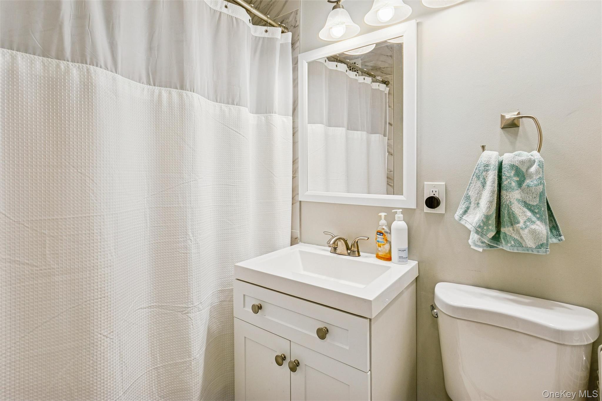 700 Shore Road, Unit 5U Long Beach, NY 11561 - Photo 18 of 21 a bathroom with a sink vanity mirror and toilet