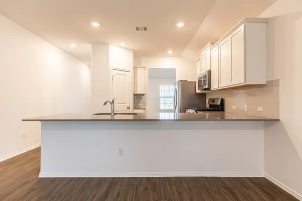 a kitchen with stainless steel appliances a sink a stove and a refrigerator