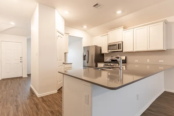 a kitchen with kitchen island granite countertop a sink stove and refrigerator