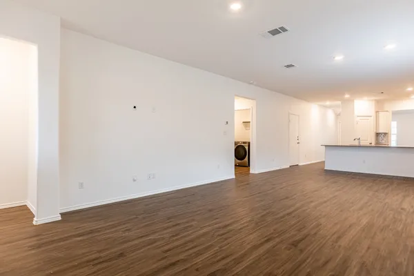 a view of a big room with wooden floor and windows