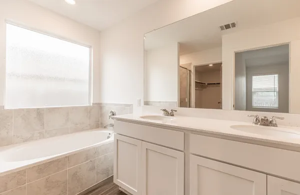 a bathroom with a granite countertop bathtub shower sink and vanity
