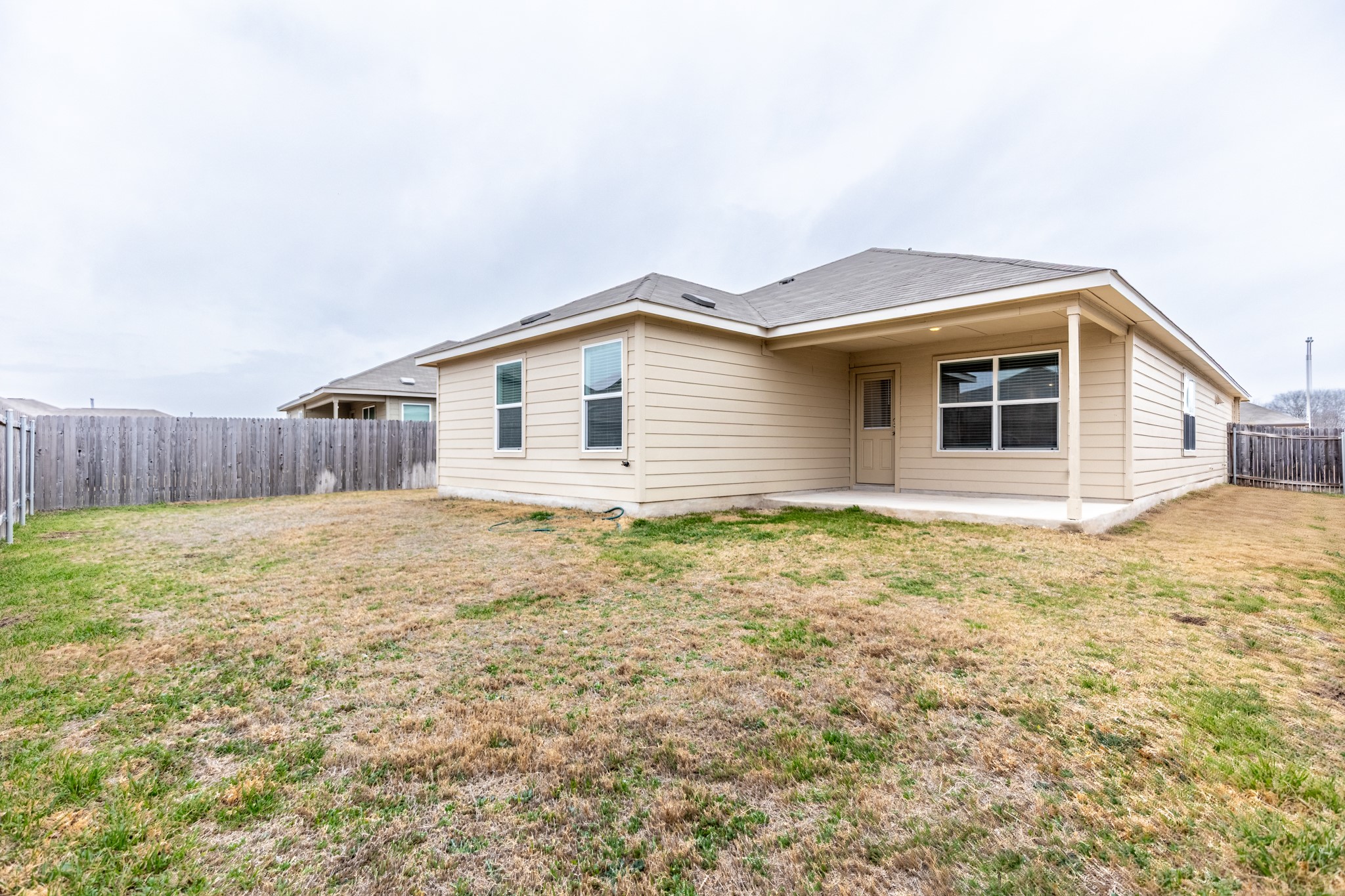 175 Silver Springs Bend Kyle, TX 78640 - Photo 32 of 33 Rear view of house with a fenced backyard and a patio