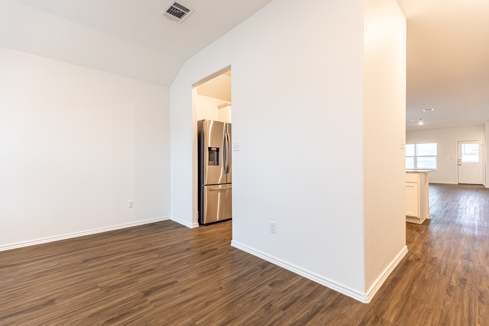 175 Silver Springs Bend Kyle, TX 78640 - Photo 4 of 33 Empty room featuring dark wood-type flooring and lofted ceiling