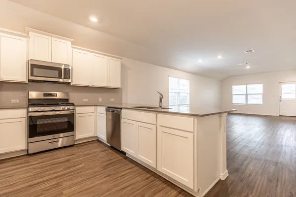 a kitchen with stainless steel appliances a white stove top oven a sink and a microwave