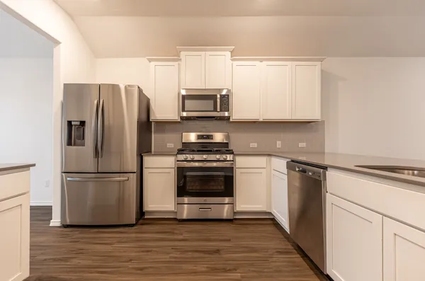 a kitchen with a refrigerator stove and microwave