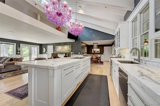 a large kitchen with kitchen island a stove a sink dishwasher and a dining table with the living room view