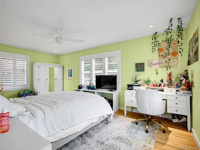a bedroom with a bed window table and chair
