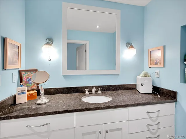 a bathroom with a granite countertop sink and a mirror