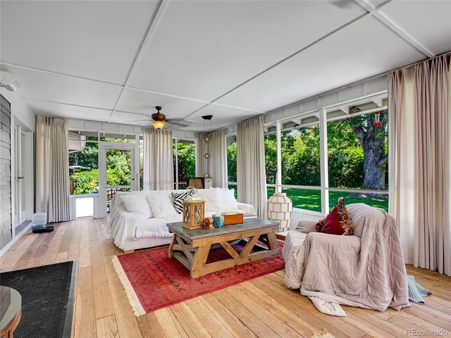 a living room with furniture and floor to ceiling windows