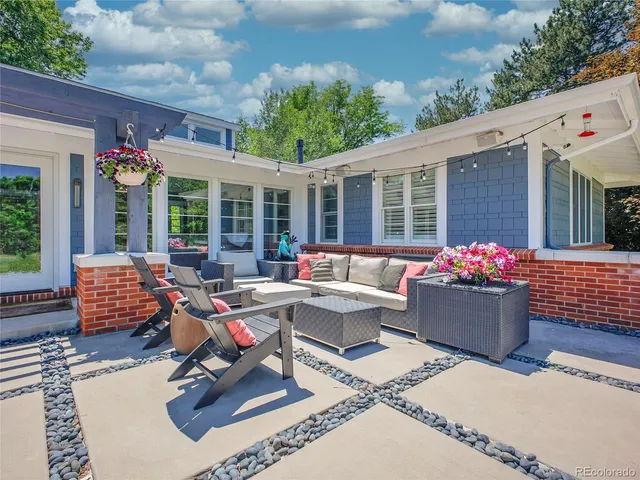 a view of a patio with table and chairs potted plants and a large tree