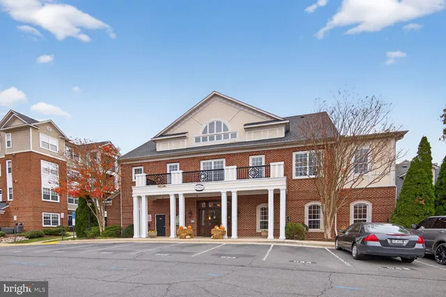 a front view of a building with cars parked on city street