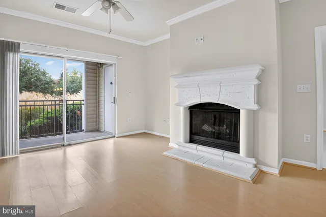 a view of an empty room with fireplace and a window