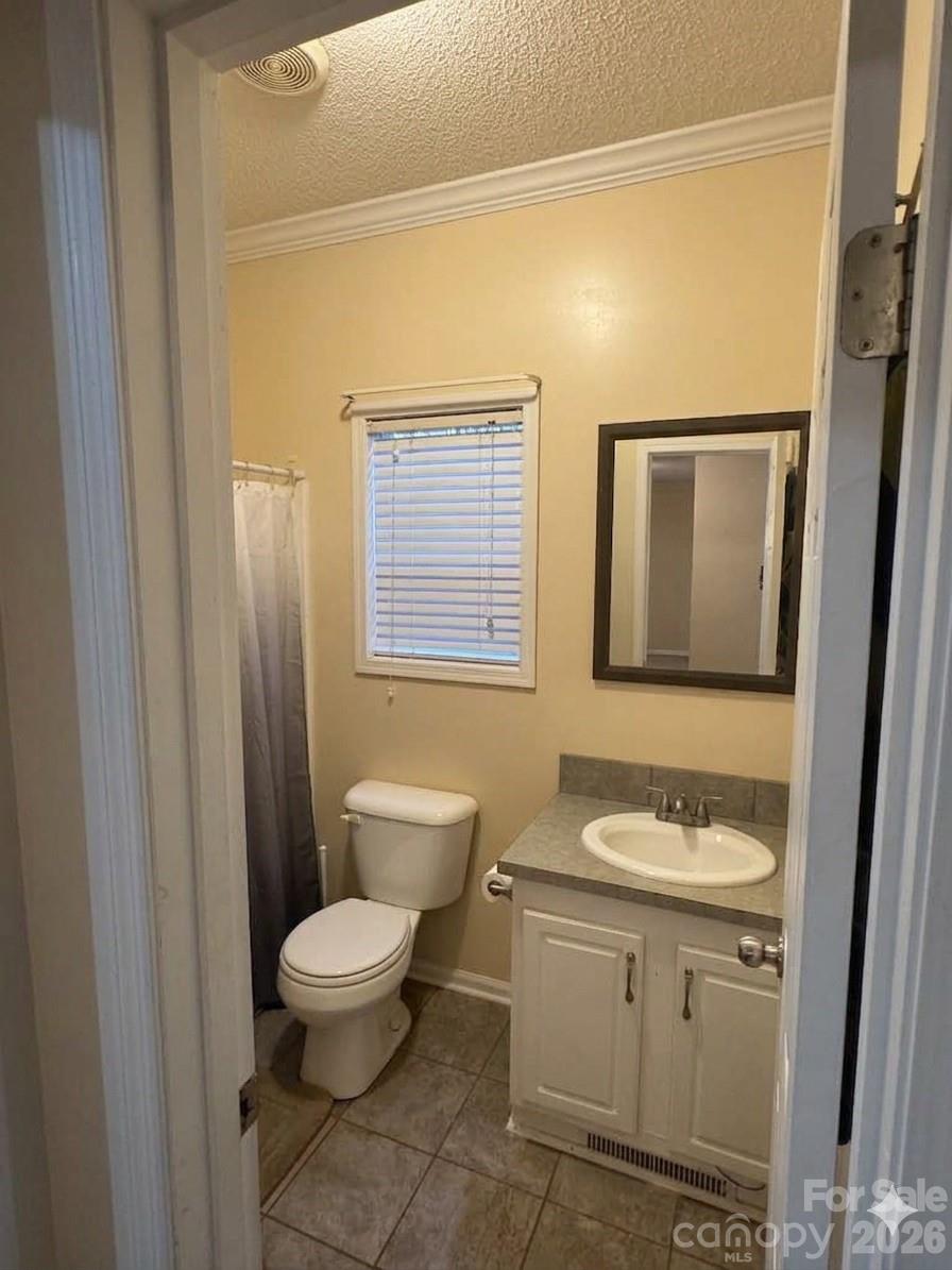 3233 Alamo Drive Trinity, NC 27370 - Photo 13 of 15 a bathroom with a granite countertop sink toilet a mirror and a shower