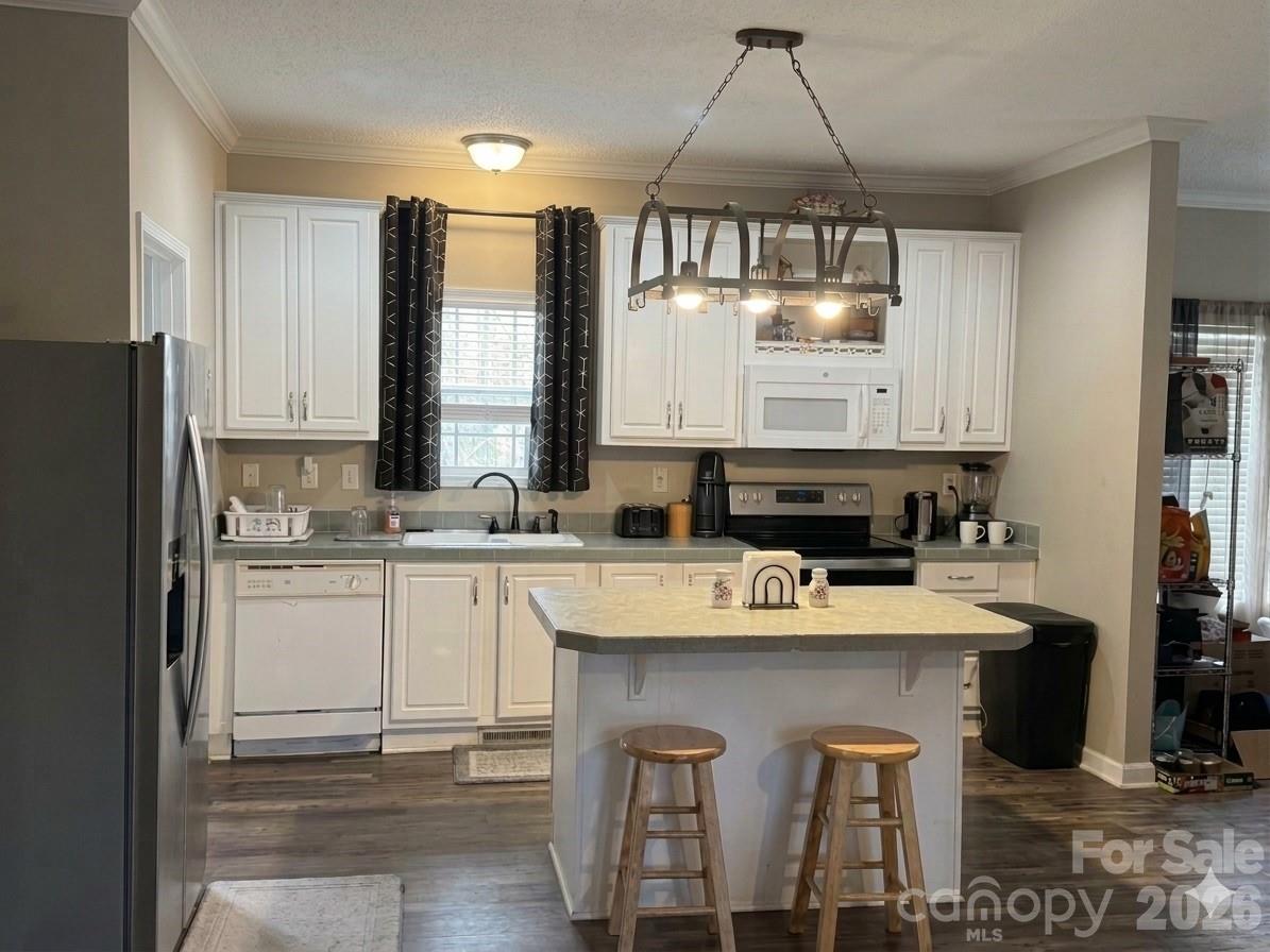 3233 Alamo Drive Trinity, NC 27370 - Photo 6 of 15 a kitchen with kitchen island granite countertop a sink a stove a refrigerator and cabinets