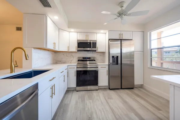 a kitchen with stainless steel appliances a refrigerator sink and microwave