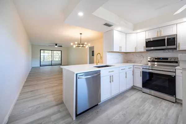 a open kitchen with a sink stove and microwave