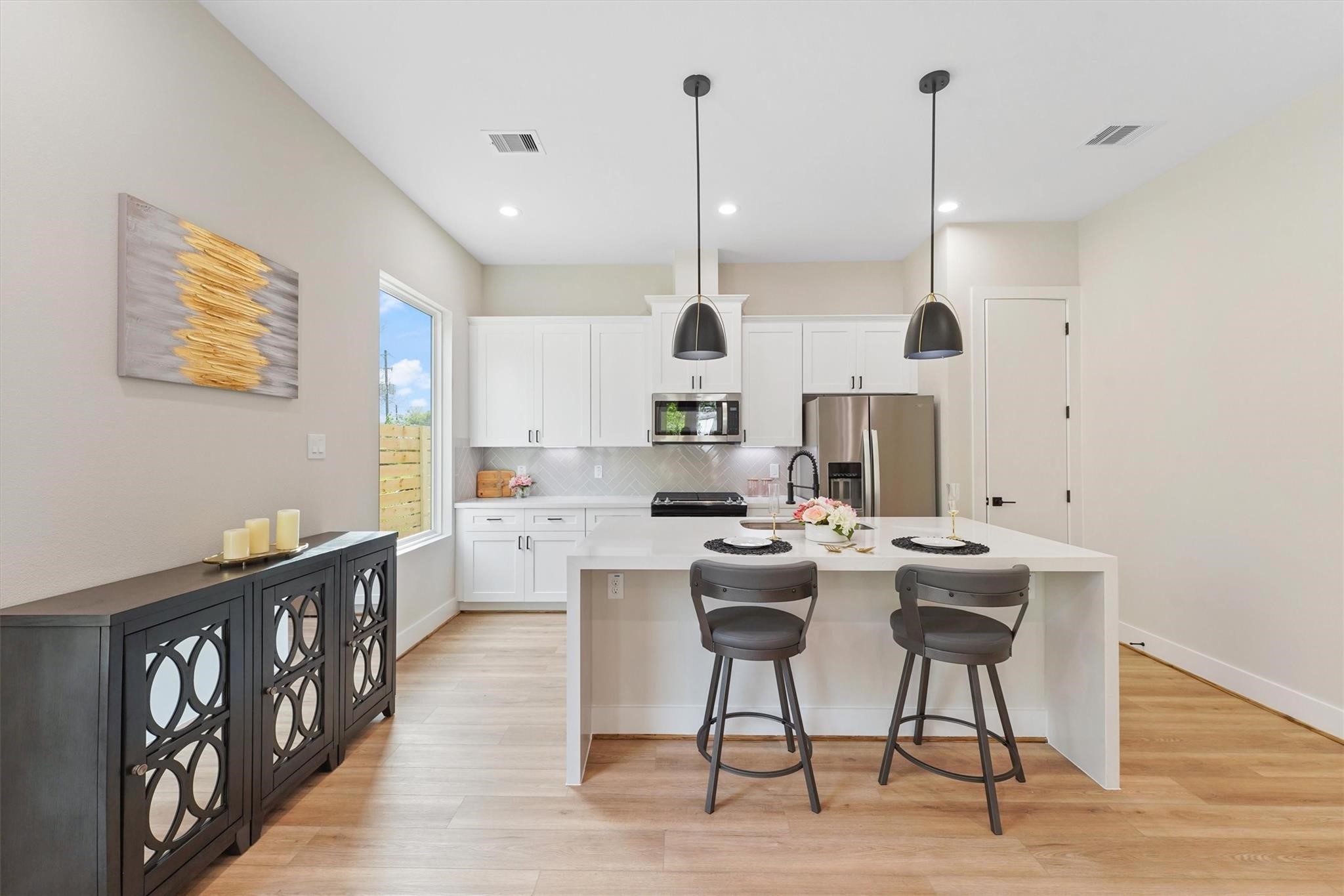 2131 Blalock Road, Unit G Houston, TX 77080 - Photo 7 of 28 a kitchen with stainless steel appliances kitchen island granite countertop a table chairs and a view of living room