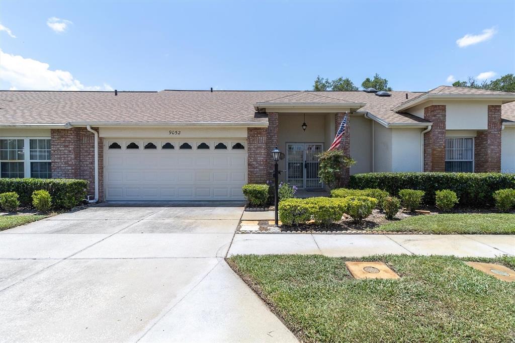 9052 Arundle Place New Port Richey, FL 34655 - Photo 29 of 57 a front view of a house with a yard and a garage