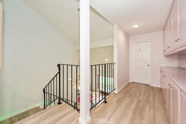 a view of a hallway with wooden floor and staircase
