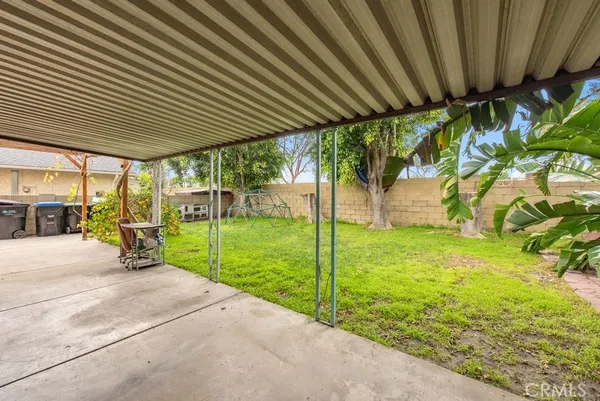 a view of a backyard with table and chairs under an umbrella