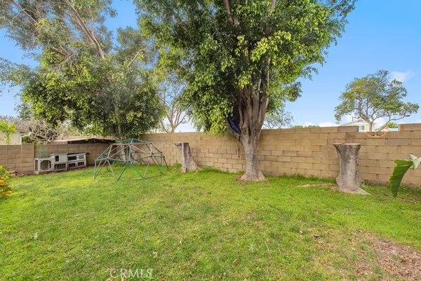 a backyard of a house with table and chairs and a large tree