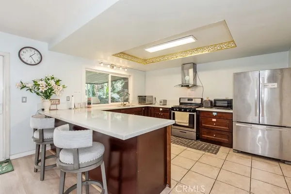a kitchen with granite countertop a table chairs stove and refrigerator