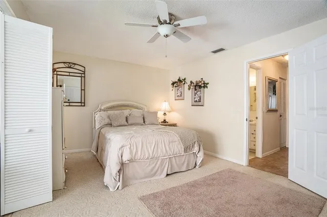 a bedroom with a bed and a ceiling fan